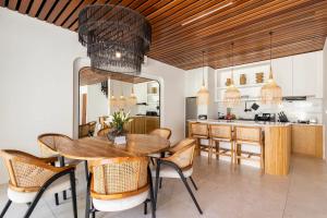 a dining room with a table and a kitchen at Unity Villas Canggu in Canggu