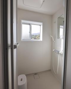 a bathroom with a shower and a window at Tainan House台南家 in Awaji