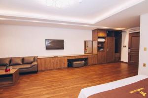 a living room with a couch and a television at THU HOTEL in Ha Long