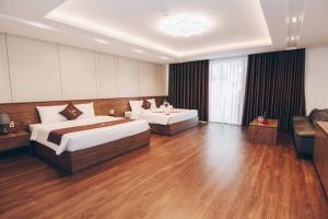 a large room with two beds and a couch at THU HOTEL in Ha Long