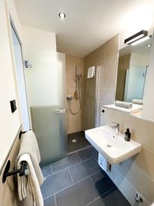 a bathroom with a sink and a shower at HOLI City Apart Hotel Berlin in Berlin