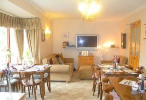 a living room with tables and chairs and a living room at Alltonside Guest House in Fort William