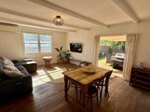a living room with a table and a couch at Barefoot Beach Cottage in Geographe