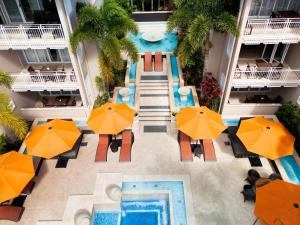 una vista aérea de la piscina en un hotel con sombrillas naranjas en Laguna on Hastings en Noosa Heads