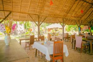 Coin Sauvage في Ambatozavavy: مطعم بطاولات وكراسي وسقف خشبي