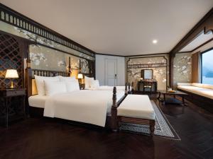 1 dormitorio con 1 cama blanca grande y 1 sofá en Era Premium Cruises Halong, en Ha Long