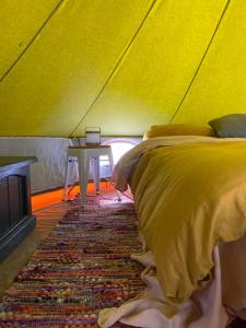 a bedroom with a bed and a table in a tent at Tocumwal Chocolate School in Tocumwal