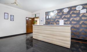 a lobby with a counter with clocks on the wall at Treebo Trend RR Residency - Sanjay Nagar in Bangalore