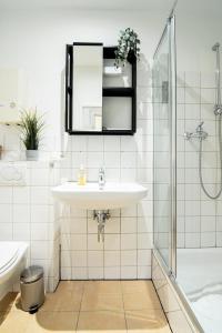 La salle de bains blanche est pourvue d'un lavabo et d'un miroir. dans l'établissement Hamburg - 2 Bedrooms for up to 11 guests, à Hambourg