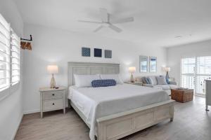 a white bedroom with a bed and a couch at Keys Wade NEW 1B 2Bath in Marathon