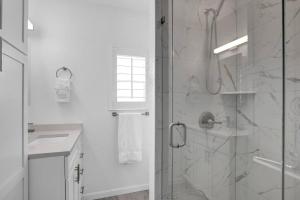 a white bathroom with a shower and a sink at Keys Wade NEW 1B 2Bath in Marathon