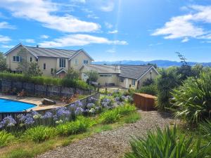a house with a garden and a swimming pool at Golden Hills Farm Cottage in Nelson