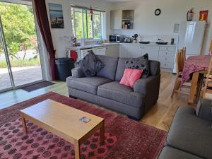 a living room with a couch and a coffee table at Golden Hills Farm Cottage in Nelson
