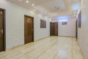 an empty room with a ceiling fan and doors at Hotel Essendi Hospitalities Llp in Kalkaji Devi