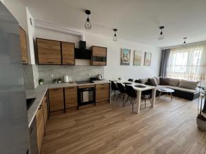 een keuken en een woonkamer met een tafel en een bank bij Kotlina Kłodzka - Apartament na Letniej in Kłodzko