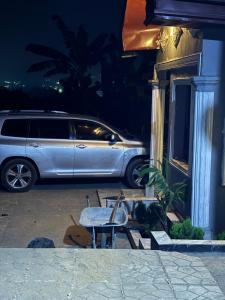 a car parked in front of a building with a bench at Eden Meadows Estate (Dr. John) in Limbe