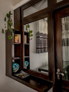 a mirror in a wooden cabinet with a plant at Secret Mountain Paradise in Ella