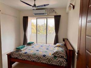 a bedroom with a bed in front of a window at Nirvana Stay, Spacious Fully furnished 2bhk apartment in Mangalore, Full AC for Family in Mangalore