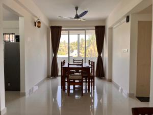 a dining room with a table and chairs and a window at Nirvana Stay, Spacious Fully furnished 2bhk apartment in Mangalore, Full AC for Family in Mangalore