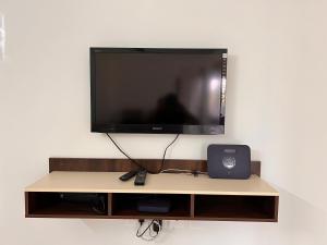 a flat screen tv sitting on top of a table at Nirvana Stay, Spacious Fully furnished 2bhk apartment in Mangalore, Full AC in Mangalore