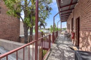 a balcony with a red railing next to a brick building at The Mess and Barracks in Ararat