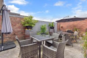 a patio with a table and chairs and an umbrella at The Mess and Barracks in Ararat