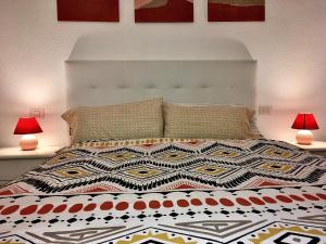 a bed with a white headboard and two lamps at Casa Dominica in La Guancha