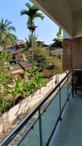 a balcony with a view of a beach and palm trees at Juliet's Homestay in Cochin