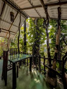 een tafel op een veranda naast een boom bij Secret Mountain Paradise in Ella