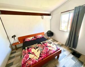 Schlafzimmer mit einem Bett und einem Fenster in der Unterkunft Maison T3 près de l’aéroport in Sainte-Marie