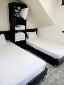 duas camas num quarto com lençóis brancos em Casa Quindio em Armênia