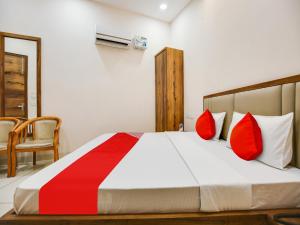 a bedroom with a large bed with red pillows at OYO K9 ORBIT in Ludhiana
