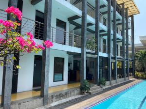 an external view of a building with a swimming pool at Olanro Hotel Negombo in Negombo