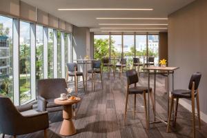 a restaurant with tables and chairs and large windows at Residence Inn Miami Sunny Isles Beach in Miami Beach