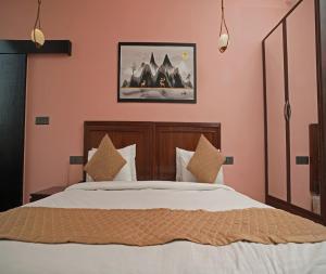 sypialnia z łóżkiem z białą pościelą i poduszkami w obiekcie Ashira Inn w mieście Greater Noida
