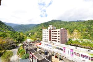 a building with a train station next to a mountain at 知本溫泉-彩溱旅宿 in Wenquan