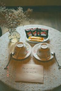 einen Tisch mit zwei Tellern und zwei Löffeln und eine Note in der Unterkunft Maison de Hill Home in Dồng Văn