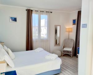a hotel room with two beds and a chair at Hotel La Villa Del Mare in Cagliari