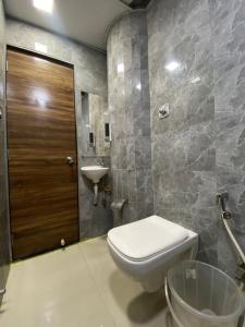 Hotel Blue Wellington - Near Mumbai Airport في مومباي: حمام مع مرحاض ومغسلة