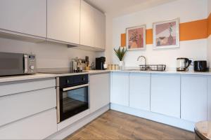 a kitchen with white cabinets and a microwave at Lake view apartment 5 minutes to city center with free parking nearby in Manchester