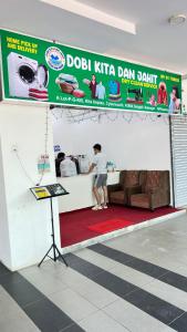 a man standing on a red rug in a room at Duan Homestay @ Cybersouth (Muslim shj) in Kampung Dengkil