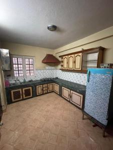 cocina con armarios de madera y suelo de baldosa en Fully furnished 1bhk flat near dhumbarahi area en Katmandú