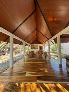 eine offene Veranda mit Holzdecken sowie Tischen und Stühlen in der Unterkunft The Grand Mango in El Gigante