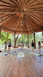 a group of people doing yoga under a large umbrella at The Grand Mango in El Gigante