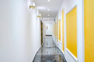 ムンバイにあるHotel Gorrionの黄色の壁とタイルフロアの廊下