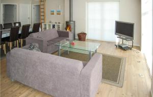 a living room with a couch and a tv at Holiday Home Pilemose Sydals in Skovby