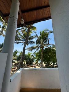 a view from the porch of a resort with palm trees at Sabine Holiday Resort and Restaurant in Matara