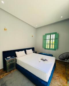 a bedroom with a bed and a green window at Charming Villa with Pool, Garden and Pingpong in Marrakech