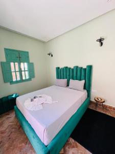 a bedroom with a large bed with green headboard at Charming Villa with Pool, Garden and Pingpong in Marrakech