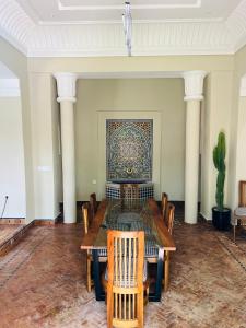 Charming Villa with Pool, Garden and Pingpong في مراكش: غرفة طعام مع طاولة وكراسي